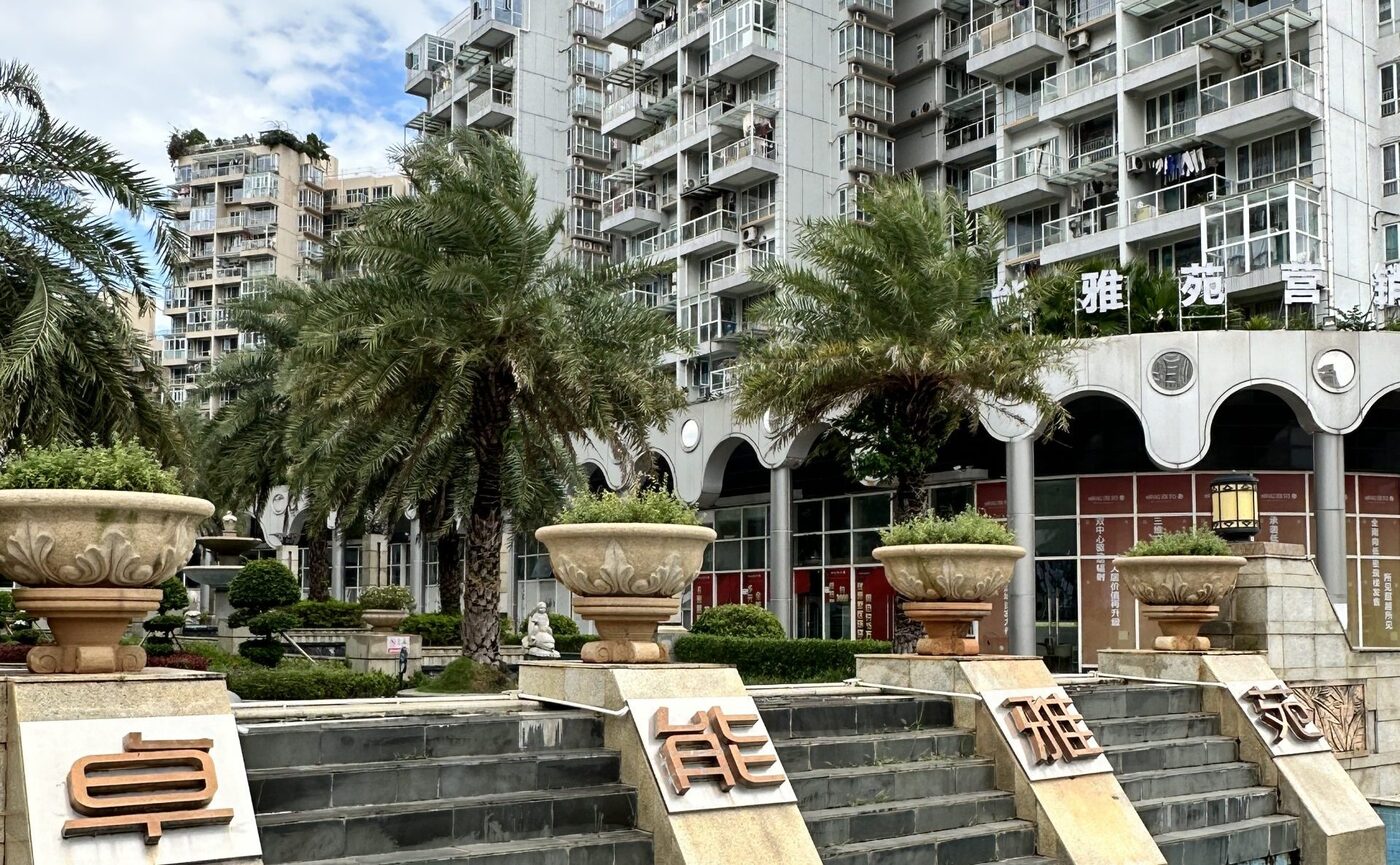 The entrance to Cheuk Nang Opulence in Shenzhen, the characters 卓能雅苑 set on plinths beside a stepped water feature
